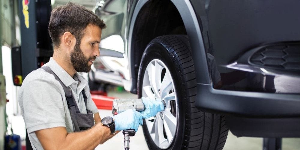 Mechanic replacing a tire on a car.